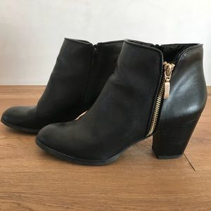 Black heeled booties with gold zipper
